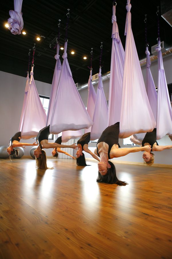 Aerial yoga class in pink hammocks